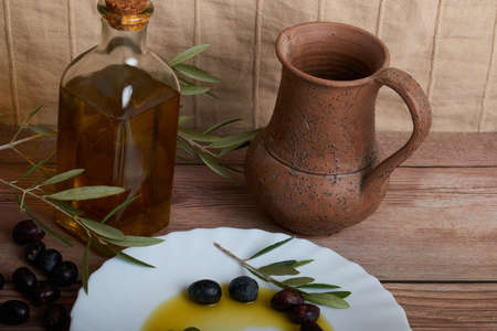 Striking oil bottles surrounded by several ripe olivesの写真素材