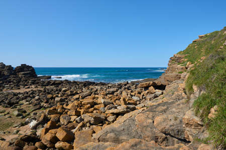 Steep cliffs with a deep blue sea and a clear blue skyの写真素材
