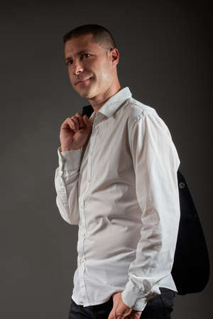 A young man in a black jacket posing in a studio.の写真素材