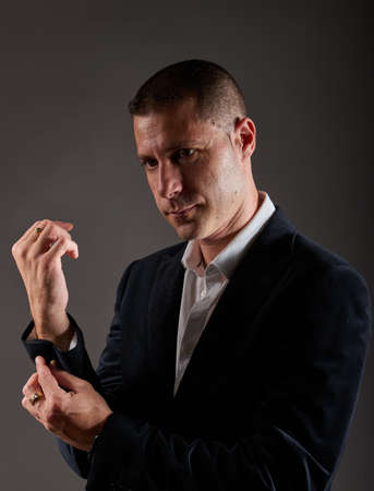 A young man in a black jacket posing in a studio.