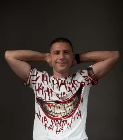 A young man in a smiling attitude posing in a studio.