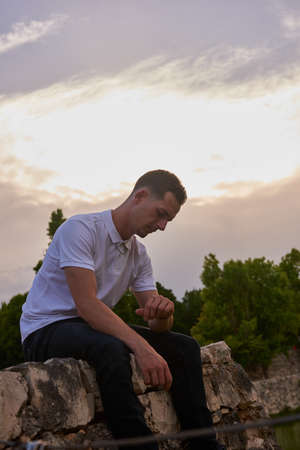 A young man in a white T-shirt posing inside a canal.の写真素材