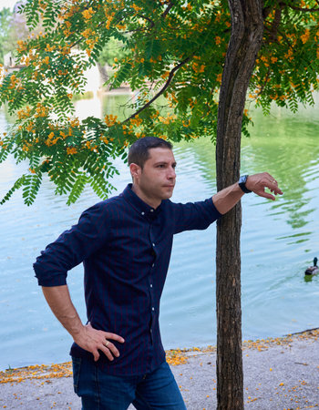 A young attractive boy in a red t-shirt posing in a park.の写真素材