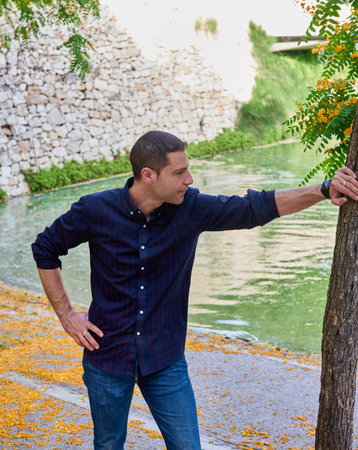 A young attractive boy in a red t-shirt posing in a park.の写真素材