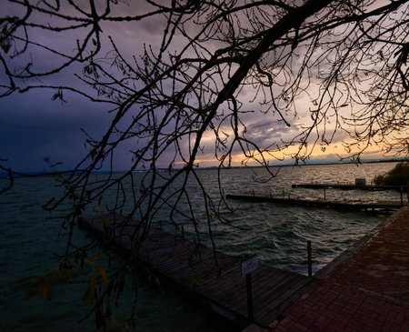 A beautiful sunset over a pier with a sky full of clouds.の写真素材