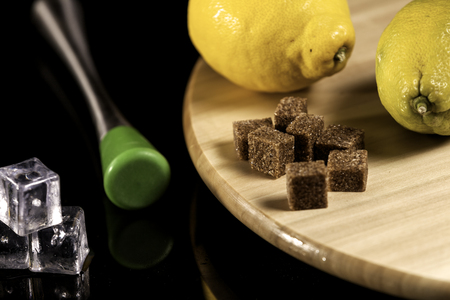 lumps of brown sugar on wood with lemons, ice cubes and a maceの写真素材