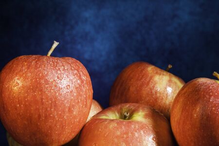 Delicious red apples group close-up on abstract blue background