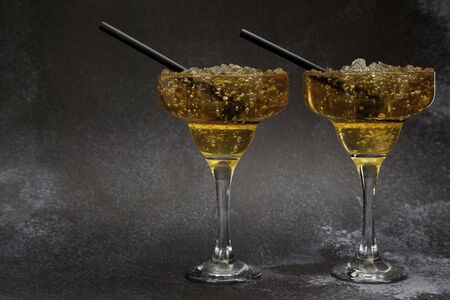 Two iced tea cocktail glass with straw on dark background with copy spaceの写真素材