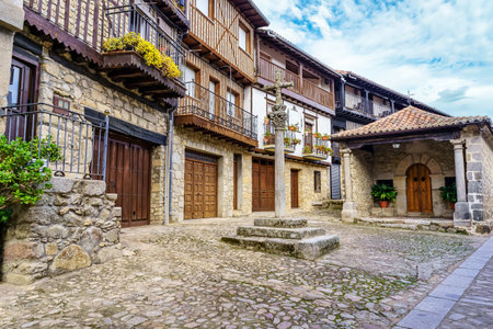 Village square with old traditional houses and stone cross, Mogarraz Salamanca.の写真素材