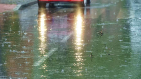 Rain falling the asphalt and car lights illuminating the scene.の写真素材