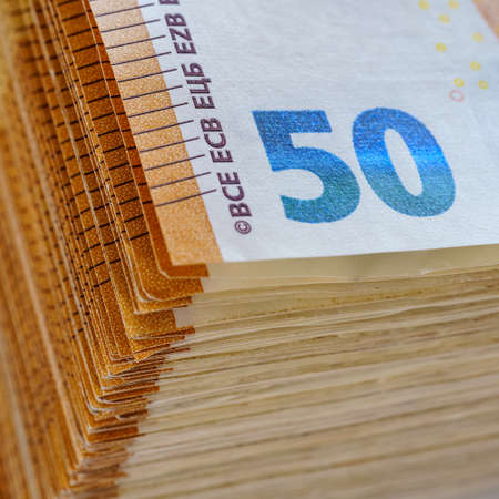 Large stack of 50 euro banknotes, European Union currency, on white background, macrophotography.