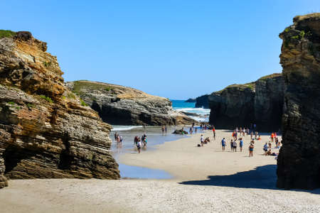 People sunbathing on the idyllic Las Catedrales beach in Galicia Spain. Lugo
