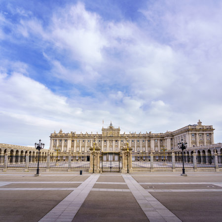 Main facade of the royal palace of Madrid with its huge esplanade and blue sky with clouds at sunrise. Spain.のeditorial素材