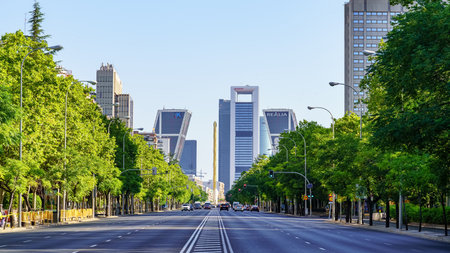 Madrid, Spain - July 30, 2022: Paseo de la Castellana in Madrid with tall company headquarters buildings and trees on the sides of the wide avenue.のeditorial素材