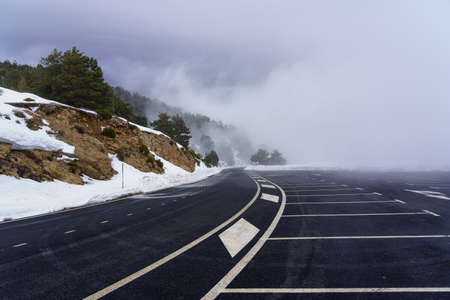 mountain road with snow and thick fog. Parking at the mountain pass.の写真素材