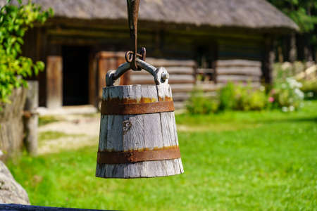 Old wooden bucket to draw water from the well in the field.の写真素材