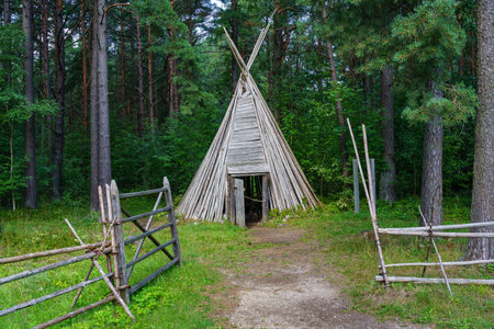 old wooden hut made of cone-shaped sticks in the forest.の写真素材