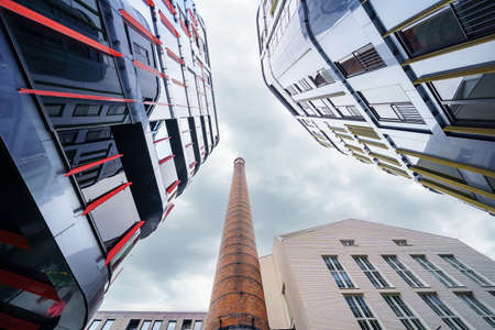 Modern glass buildings next to old factory brick tower. Tallinn Estonia.