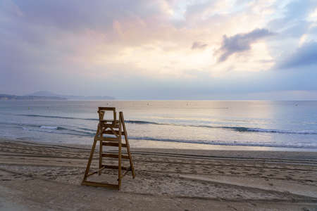 Lifeguard chair facing the sea at sunset with calm sea.