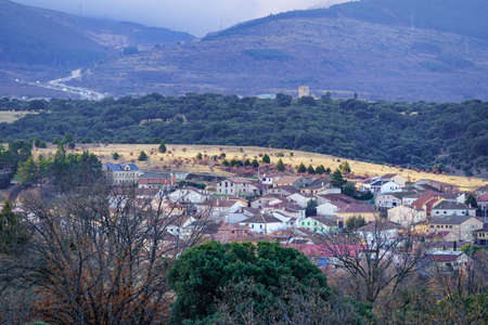 Mountain village on the hillside with green vegetation and fog in the background. Somosierra,...
