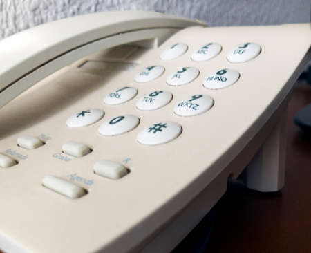 Old white telephone with round keys isolatedの写真素材