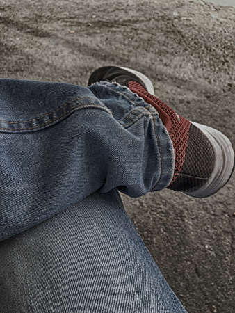 Waiting sitting with jeans and sneakers
