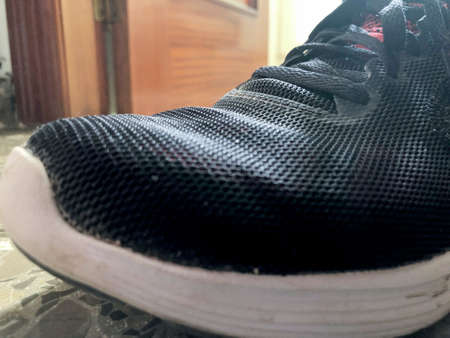 Black fabric running shoe with white sole in the foregroundの写真素材