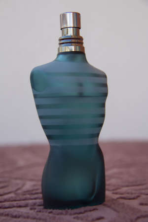 perfume bottle in the shape of a man s body, blue, brown on the table in white backgroundのeditorial素材