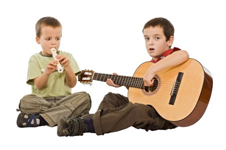 Two children sitting on the floor and playing with musical instruments