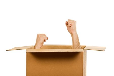Hands with clenched fists inside of the carboard box