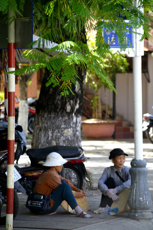 Vietnamese women sitting at street corner chattingのeditorial素材