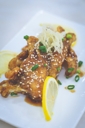 deep fried fish drizzled with teriyaki sauce and sesame and spring onion scallion on topの写真素材