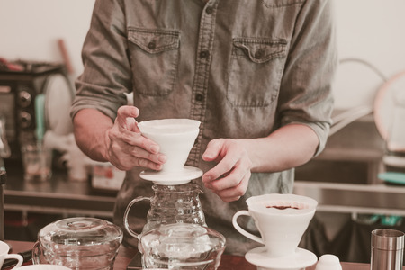 Cafe barista making specialty coffee with coffeee filter  in a cafeの写真素材