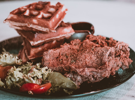 Chef signature crispy chicken served on homemade waffles with maple syrup