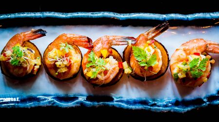 Daily-caught sea shrimp, pan-seared with chilli and topped with warm salsa on a crispy plantain coracleの写真素材