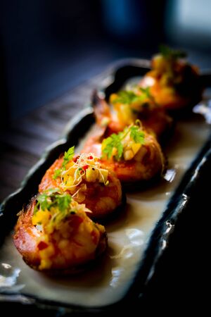 Daily-caught sea shrimp, pan-seared with chilli and topped with warm salsa on a crispy plantain coracleの写真素材