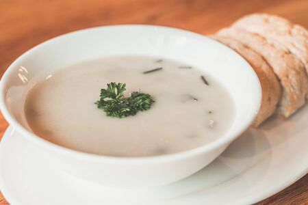 Cream of mushroom soup and garlic bread on the sideの写真素材