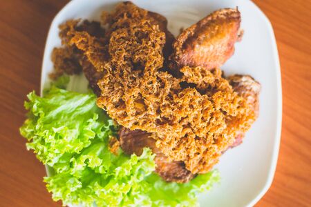 Prawn paste crispy fried chicken served on lettuce leaf and white plate