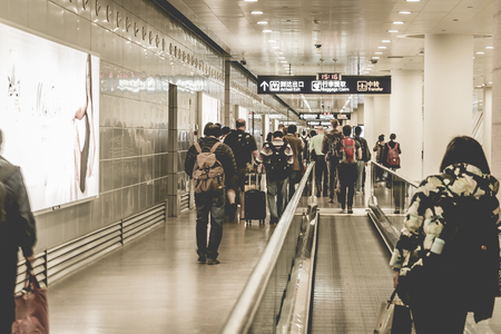 air traveller passengers hurrying towards immigration inside Shanghai Pudong Airport Terminalのeditorial素材