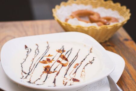 German cuisine of Creamy Potato soup with Fresh Herbs and Crispy Bacon Bits and Pretzel and Butterの写真素材