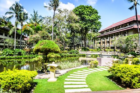 balinese doorway and architecture and fountains with trees and flora surrounding itの写真素材