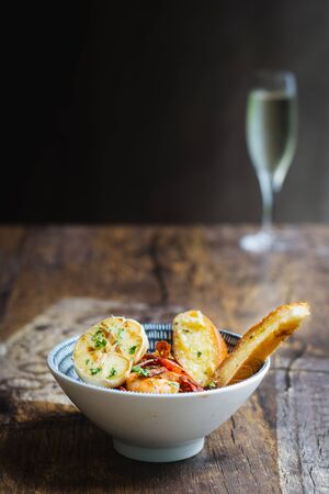Prawns Al Ajillo with garlic, fried garlic, chilli oil and garlic bread in a bowlの写真素材