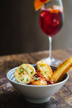 Prawns Al Ajillo with garlic, fried garlic, chilli oil and garlic bread in a bowlの写真素材