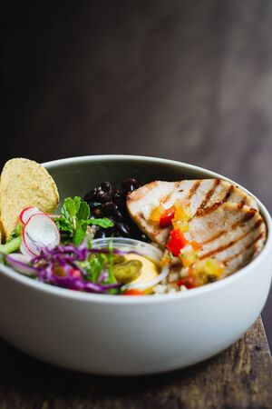 Cerdo Bowl of Roasted pork, pilaf rice, black beans, salad and banana chipsの写真素材