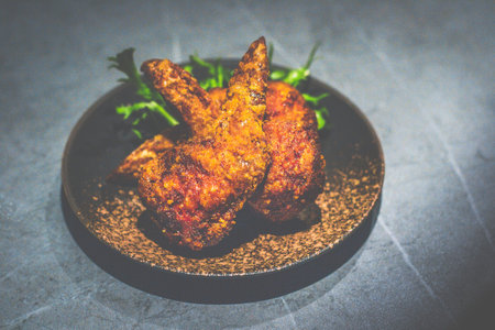Gyoza Wings made up of Chicken Wings, minced pork, cabbageand served on a small black dishの写真素材
