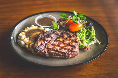 Ribeye steak withMashed potato and gravy, mesclun salad and mushroom sauce