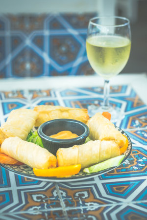 cheese roll with thousand island sauce, sliced lettuce and sliced oranges on the side