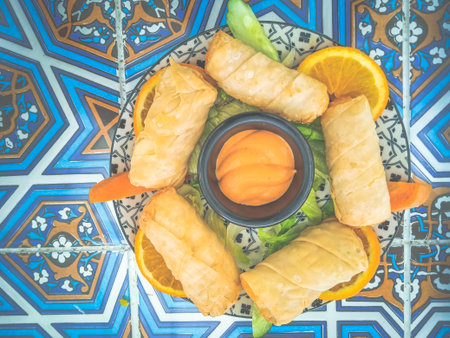 cheese roll with thousand island sauce, sliced lettuce and sliced oranges on the side