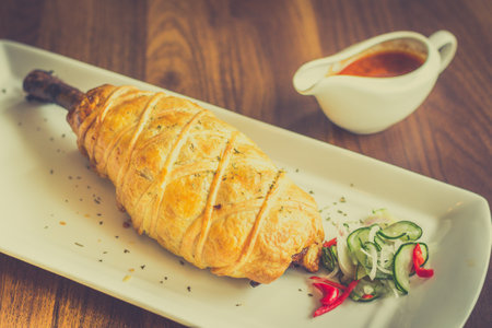 Slow-cooked, fall off the bone lamb shank rendang wellinton encrusted in buttery pastryの写真素材