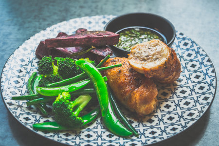 Roasted Chicken Roulade Roasted sweet potatoes, steamed green vegetables, chimichurri sauceの写真素材